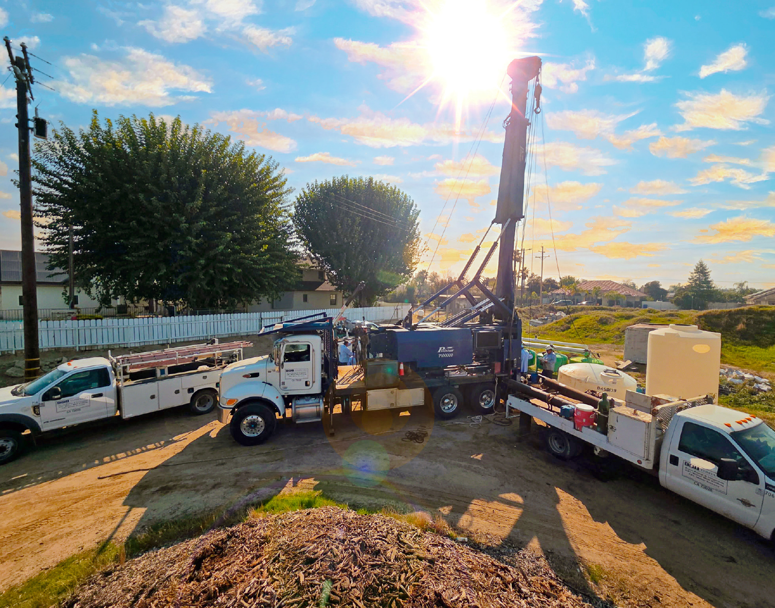 Farm Pump & Irrigation water well drilling rig and service trucks on a jobsite in California's Central Valley